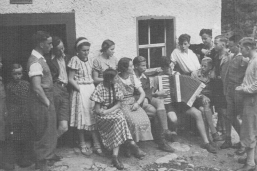 Altes schwarz-weiß Bild einer Schulklasse mit einem Akkordeon-Spieler