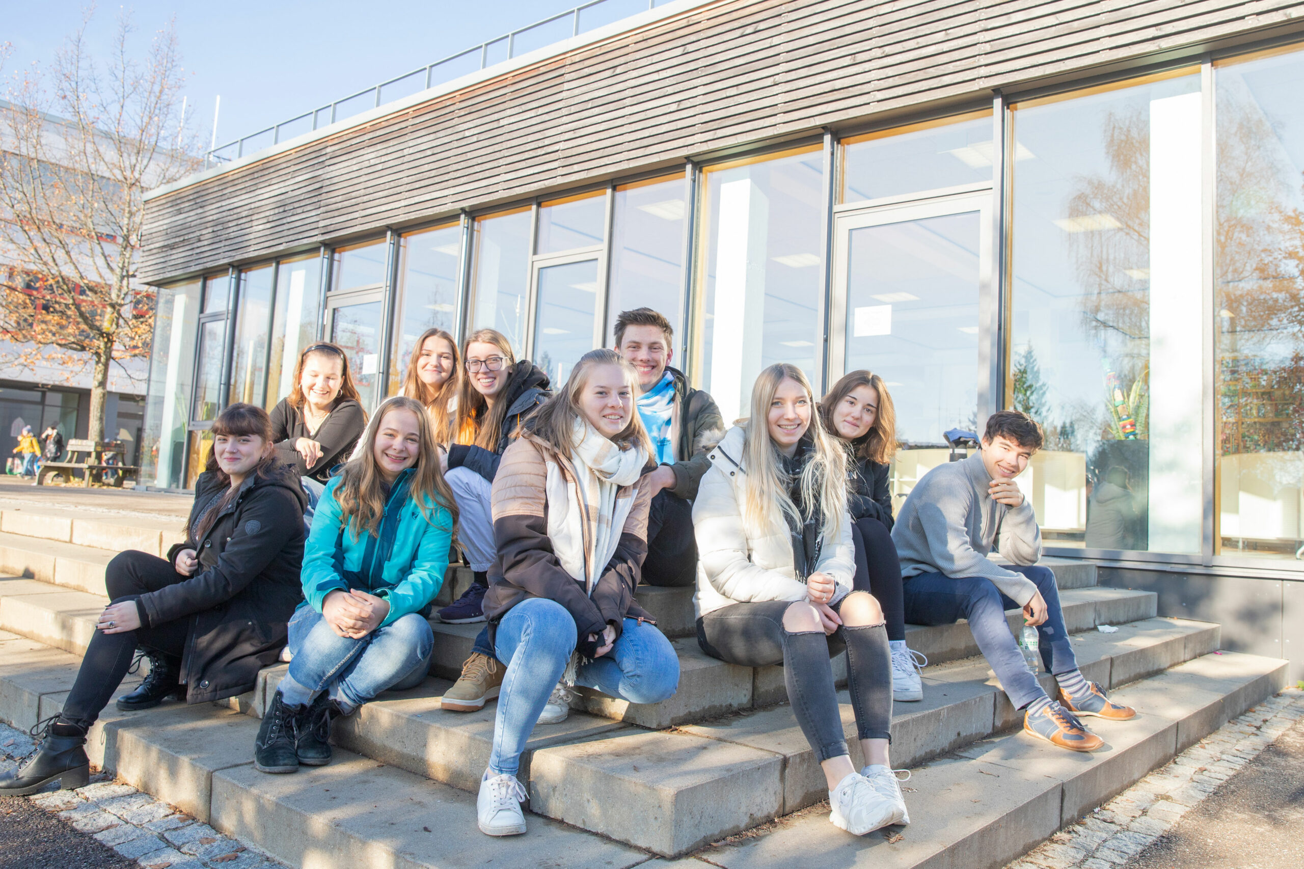 Schülergruppe sitzt auf der treppe vor dem im Fürstenberg-Gymnasium Donaueschingen