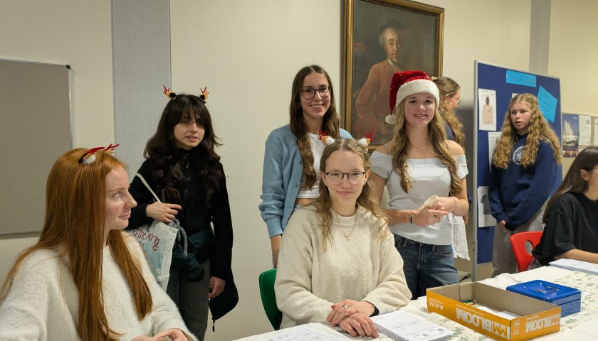 Schülerinnen und Schüler präsentieren an ihren Ständen verschiedene Dinge zum Verkauf.