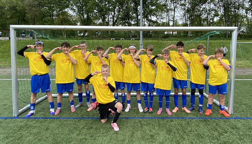 Größere Spieler mit gelbem Sieger-T-Shirt und Michel Olise-Sieger-Pose: Team 1 aus der Altersgruppe U15: Turniersieger