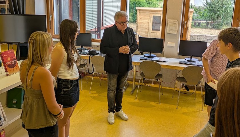 MdL Guid Wolf spricht mit den Schülerinnen über ihre Wettbewerbsprojekte.