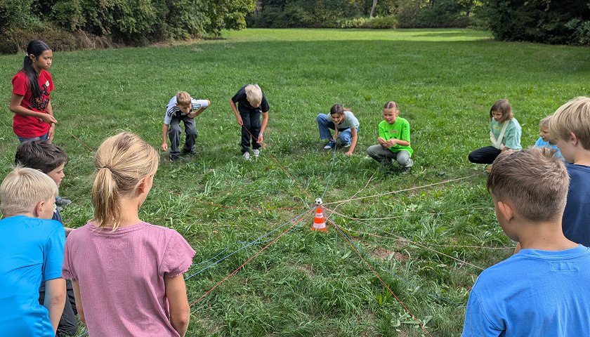 Fünftklässler absolvieren im Schlosspark verschiedene erlebnispädagogische Spiele.